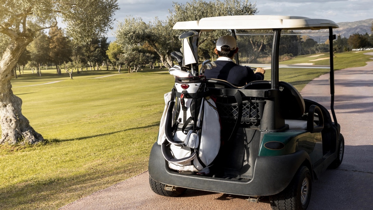 man-with-golf-cart-carrying-clubs